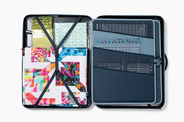 Rulers in their sleeves on one side, fabric and a quilt strapped in on the other.